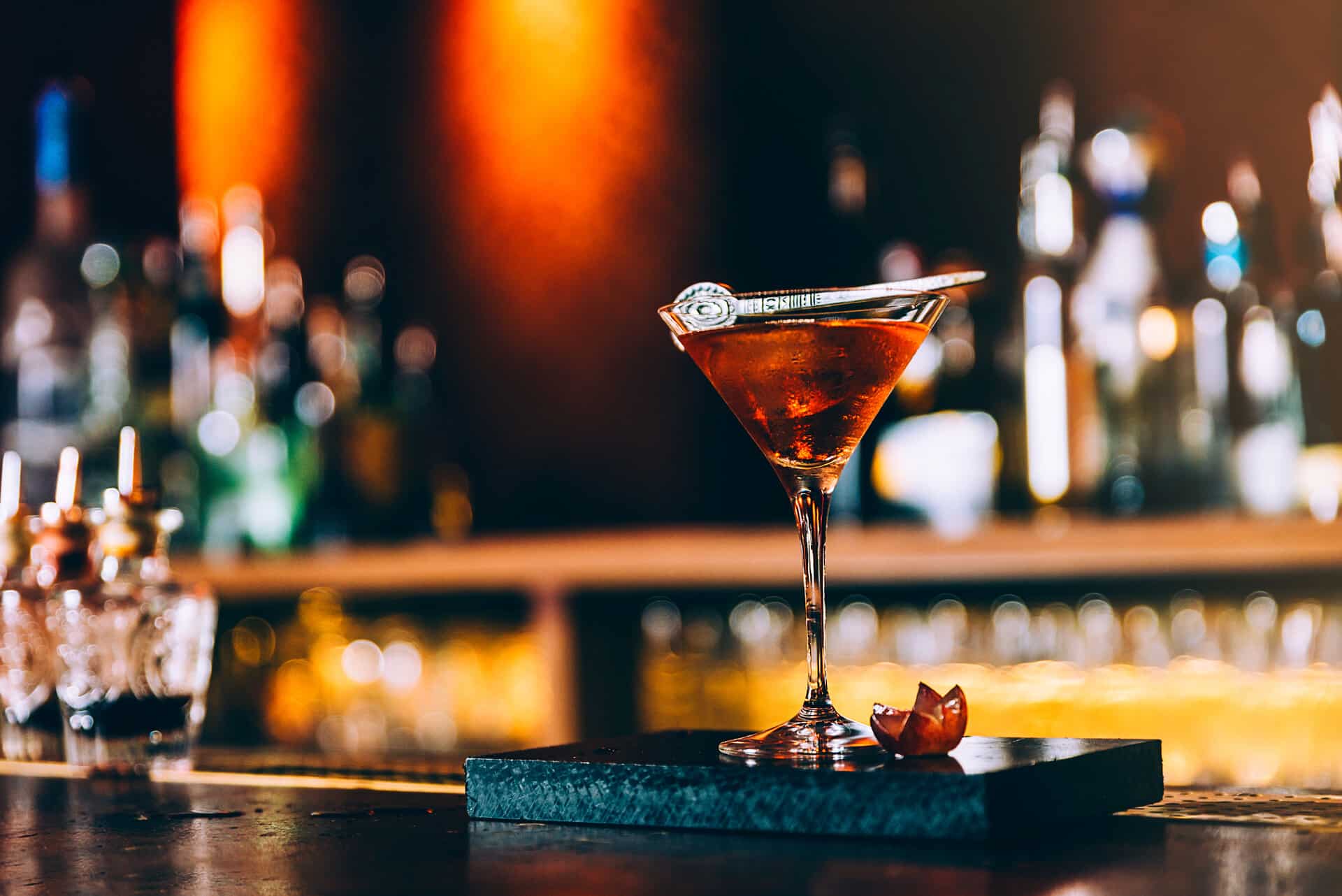 rot leuchtender Cocktail in Martiniglas auf Bartresen