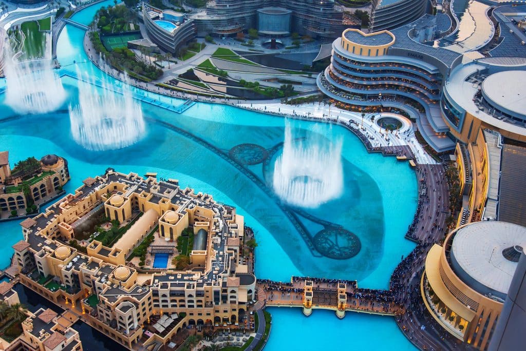 Dubai, United Arab Emirates – July 5, 2019: Dubai mall fountain show surrounded and modern downtown buildings top view Dubai, United Arab Emirates - July 5, 2019: Dubai mall fountain show surrounded and modern downtown buildings top view