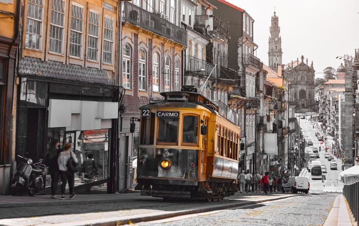 Porto, Portugal. Antique retro tram on the rails. Public transport with tramway road. Popular touristic porto street during sunset.