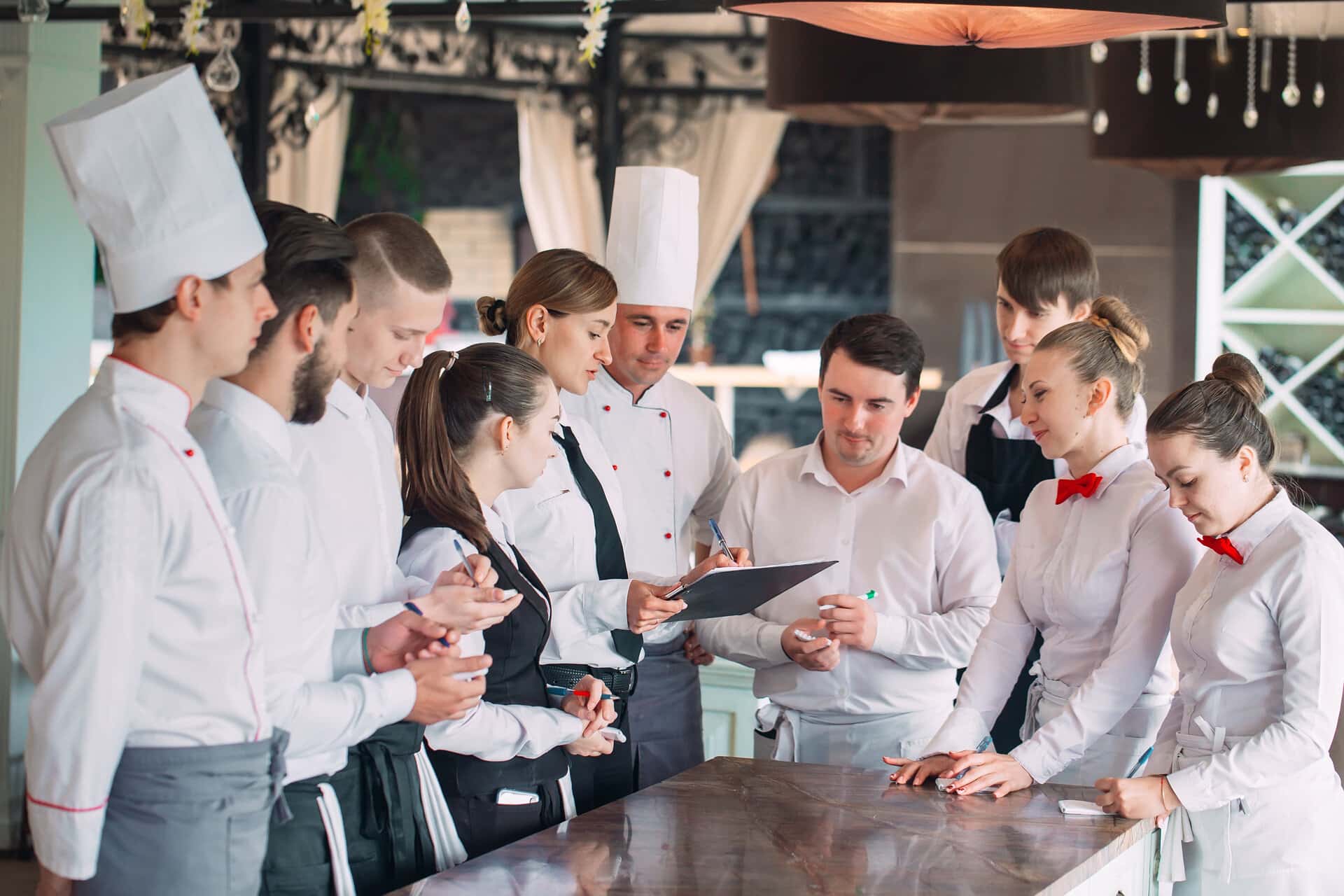Restaurant Manager und seine Mitarbeiter beim Arbeitsgespräch in der Küche