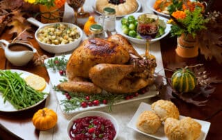 Thanksgiving Menü mit Truthahn und Beilagen, Soße, Rosenkohl, grüner Spargel, Preiselbeeren etc. auf einem Tisch