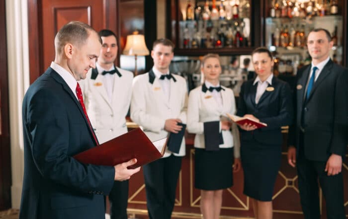 Restaurantleiter mit Mitarbeitern beim Teamgespräch im Restaruant.