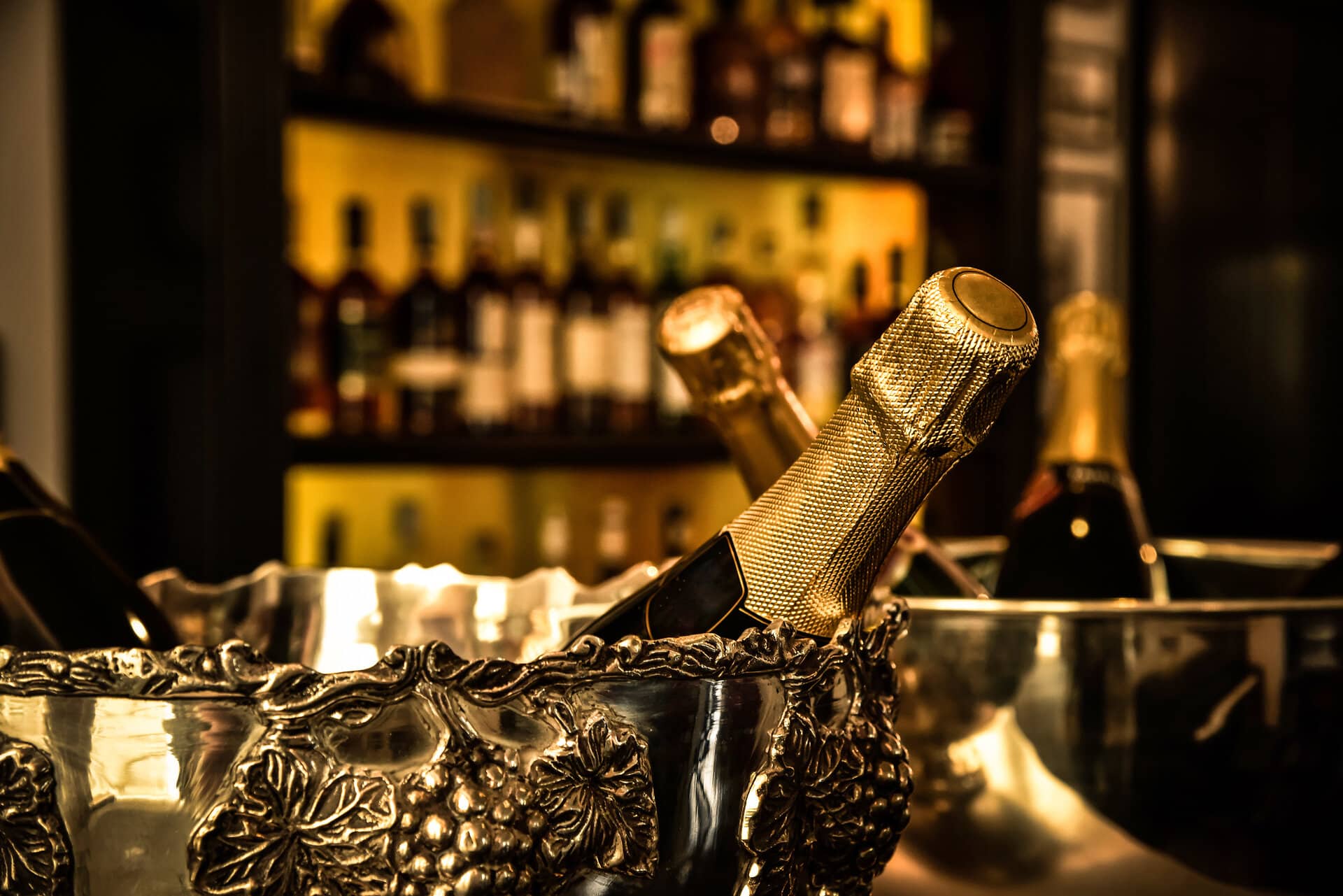 bottiglie di spumante in un cestello di un bar Champagnerflasche in großem Sektkühler auf einer Bartheke
