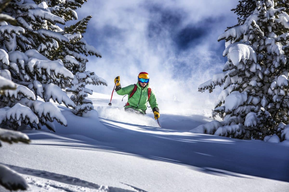 Skifahren: Skifahrer fährt durch tiefen Neuschnee