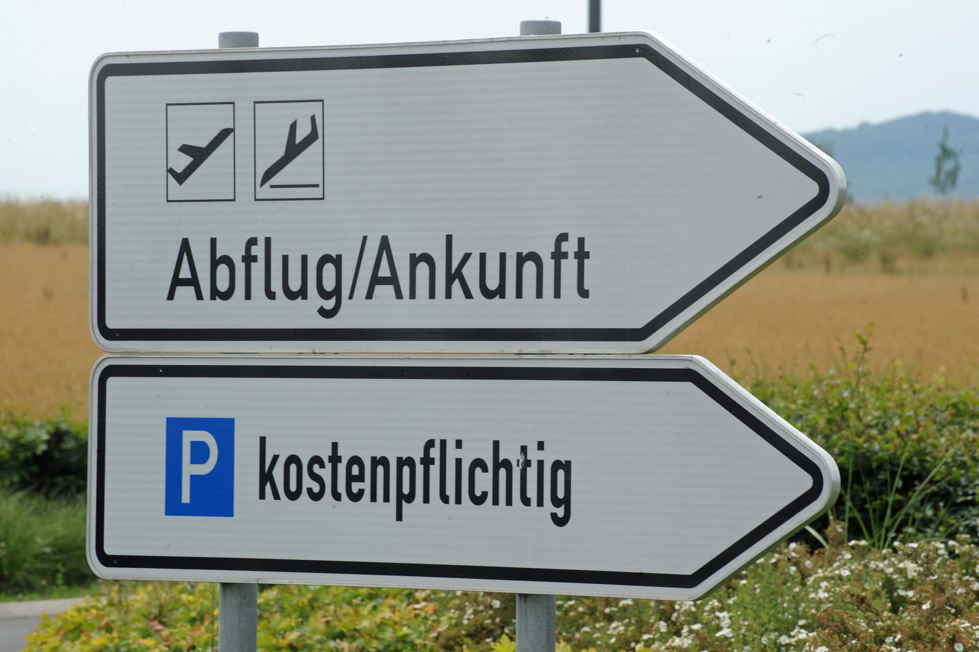 Schilder zum Flughafen und kostenpflichtigem Parkplatz