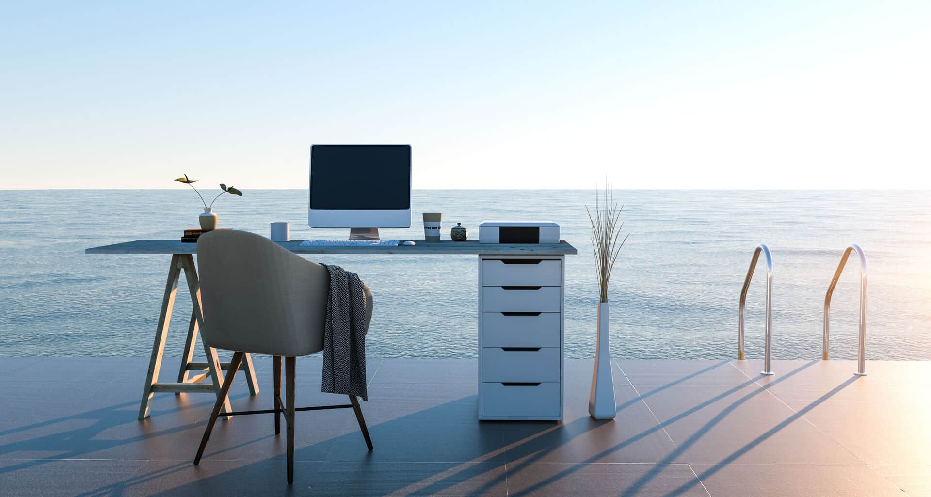 Schreibtisch mit Computer mit Leiter zum Meer