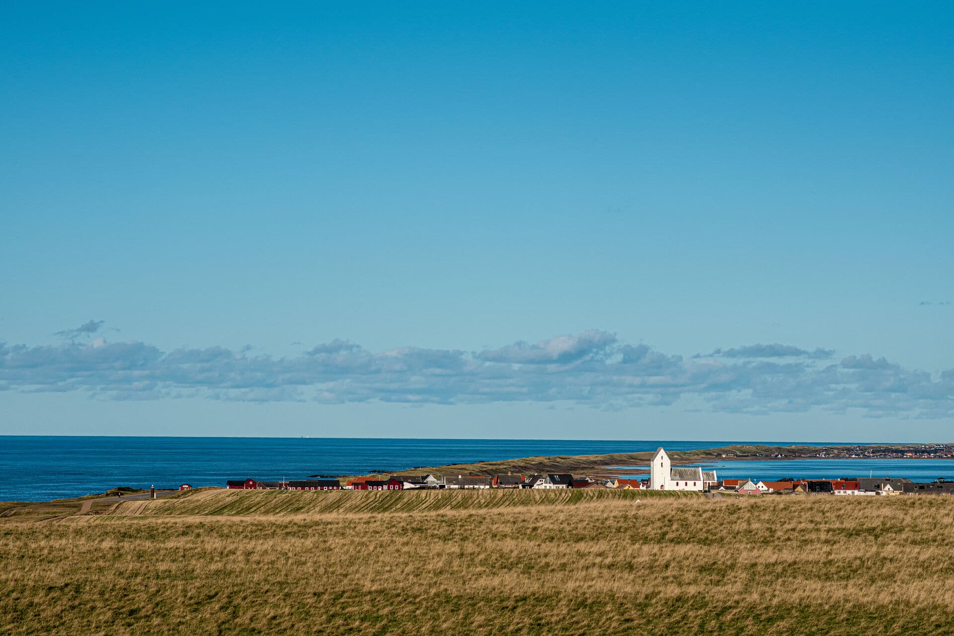 blauer Himmel über einem kleinen Dorf an Dänemarks Westküste