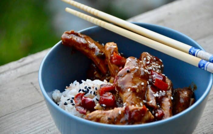 Sichuan-Chicken mit Reis in einer Schale mit Stäbchen