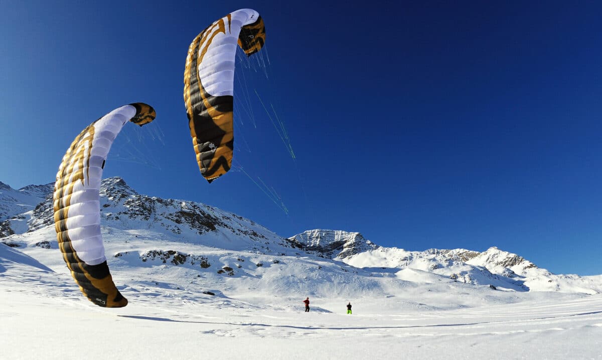 Zwei Snowkiter im winterlichen Hochgebirge