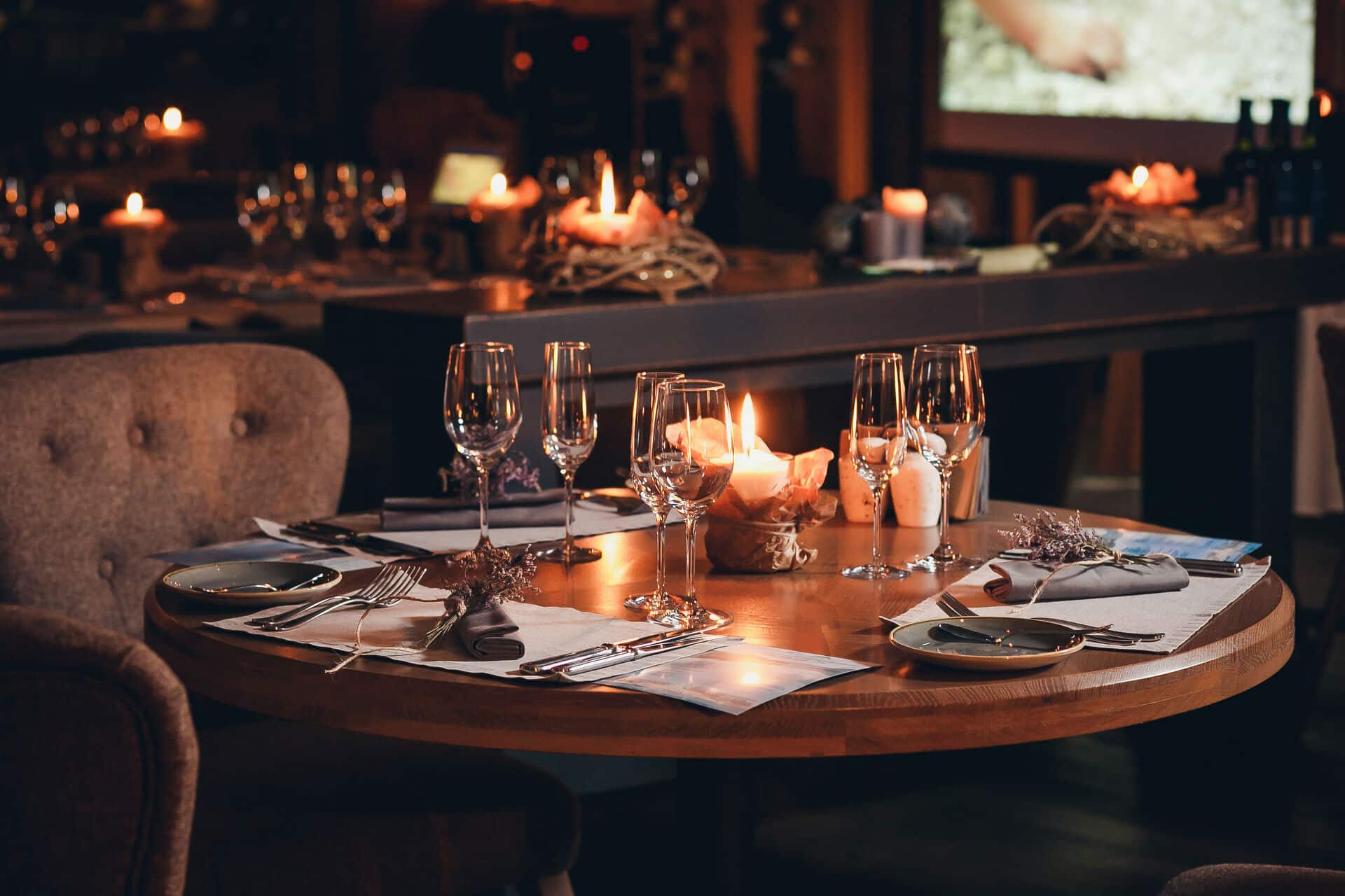 Holztisch mit Gedeck und Kerzen im Restaurant