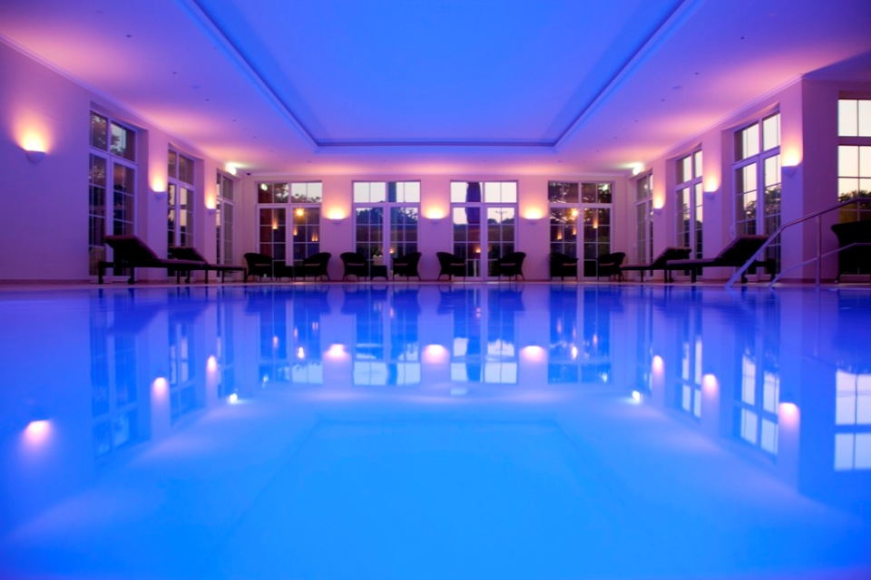 abendlich beleuchter Pool im Badehaus im Parkhotel Surenburg